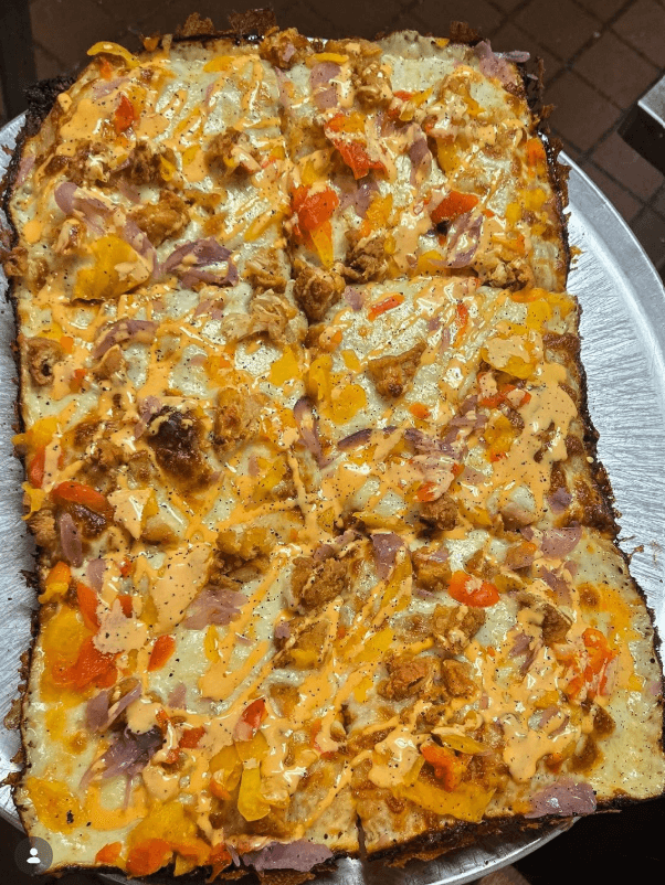 Rectangular pizza drizzled with King Sauce